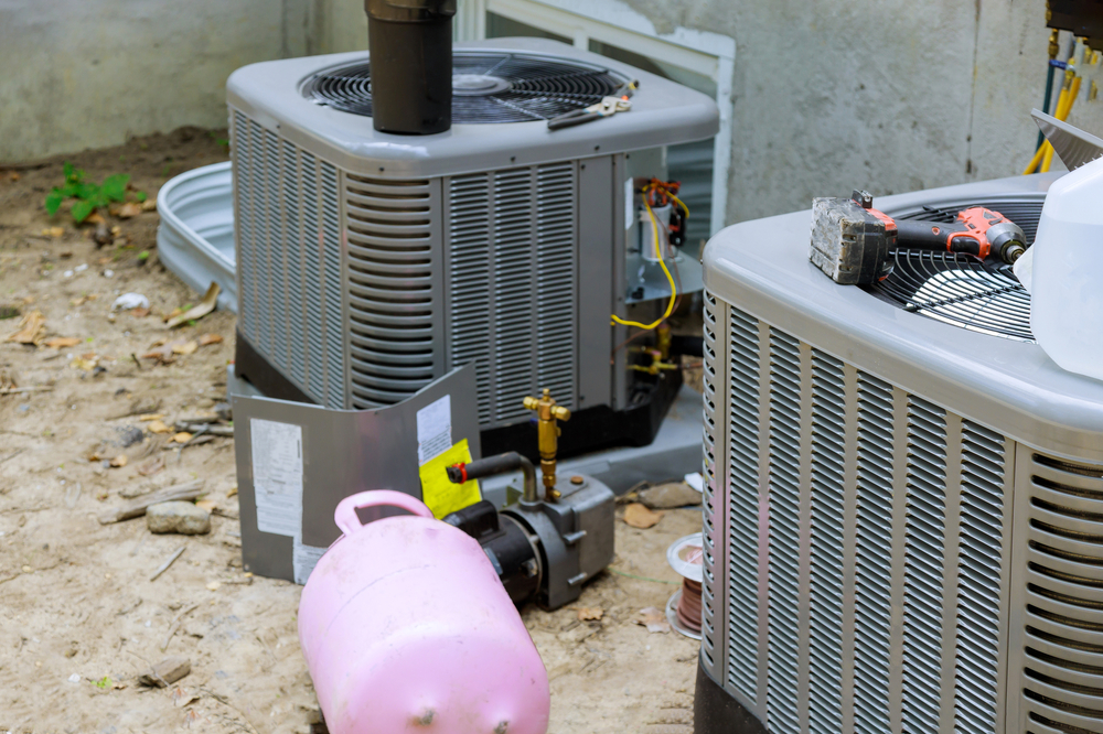 HVAC technician performing affordable AC repair on a residential air conditioning unit during summer heat